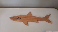 Full length overview of shark-shaped wooden charcuterie board showing fins and overall shape