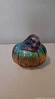 Side view of the glass pumpkin showing blue and brown gradient with twisted stem