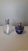 Front view of clear glass and blue ceramic Lampe Berger fragrance lamps with silver tops