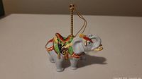 Side view of the Lenox porcelain carousel elephant ornament, showing detailed colorful saddle and gold accents.