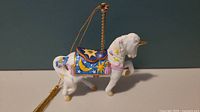 Side view showing detailed painted decoration and the gold hanging loop on the Lenox unicorn carousel ornament