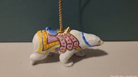 Side view of Lenox carousel polar bear ornament showing detailed carousel saddle and hanging loop.