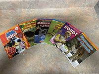 Photo showing six children's educational books with varied themes including animals, space, and robots.