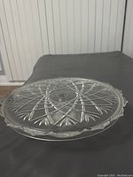Top-down view showing detailed geometric and floral-cut pattern on the glass cake dish, scalloped edges visible.