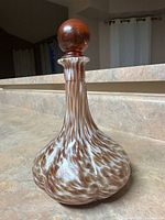 Glass decanter with stopper on kitchen counter, showing swirl pattern