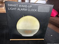 Smart Wake-Up Light Alarm Clock box showing front view with digital display illustration.
