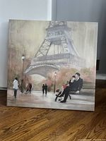 Front view of the canvas painting showing Eiffel Tower scene with people.