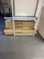 Shelving unit with Reno LED Lighting boxes and loose tubes visible.