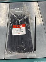 Open bag showing black releasable nylon cable ties with Uline label visible.