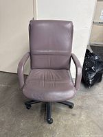 Front view of mauve desk chair showing padded seat, backrest, and armrests on black 5-wheel base.