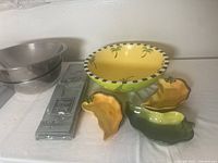 Top angle showing large metallic bowls, green napkins, wooden bowl, and ceramic chili plates.