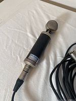 Close-up photo of the Baby Bottle microphone showing the distinctive round metal mesh grille and black body with label.