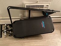 Image showing one Life Gear black inversion table laying flat with padded backrest and steel frame