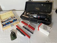 Full view of rotary tool with black plastic carrying case and various accessories including drill bits box, wool carving tool, and red black tool attachments.