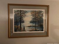 Framed watercolor painting showing a peaceful waterside landscape with trees and water reflecting the sky and trees.