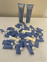 Two large tubes of Phytomer Oligopur Purifying Cleansing Gel with many smaller assorted purse size tubes of Phytomer creams and gels spread around them on a white surface.