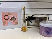 Overview of the lot showing the Artwick candle kit, Calm Club candle gift set, giraffe perfume bottle, and Quo lavender bath salts.