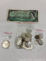 Overview of banknote plus three bags of coins on white surface