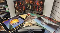 Front view of five LP covers including Def Leppard – Pyromania and Saxon – Wheels of Steel