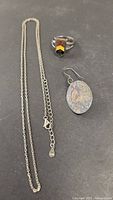 Necklace chain, ring and single earring laid flat to show overall lot items and condition