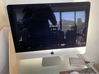 Front view of silver Apple iMac 21.5-inch all-in-one on desk