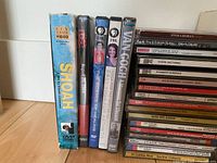 Photo of several DVDs including Shoah, yoga, Van Gogh and others standing upright.