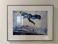 Framed Chagall poster print depicting two floating figures over a village, with matting and glass in a silver frame
