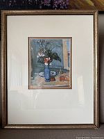 Framed art print showing a still life scene with flowers, vase, and fruit. Frame is wooden with an off-white mat.