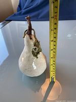 Side view showing full height of the pear-shaped pottery with measuring tape indicating approximately 8 inches tall