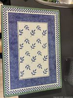 Close-up of one Villeroy & Boch hardback placemat showing blue leafy design with checkered border