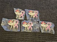 Five Jessica Rabbit pins sealed individually in plastic, showing Jessica seated next to a pink ribbon.