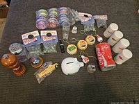 Overview of most soda collectibles laid out on a couch, including keychains, salt and pepper shakers and miniature toys.