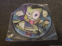 Photo of the first Invader Zim picture disc record showing Zim and classmates in a classroom setting, sealed in plastic.