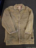 Full jacket laid flat showing front, button closure, collar, and trim details.