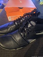 Nike Huarache black sneakers, size 10.5, with original orange Nike box in the background.