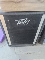 Front view of the Peavey speaker cabinet showing black mesh grille and silver Peavey logo with gray side trim.