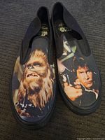 Front view of slip-on Star Wars shoes showing both left and right shoes with clear character prints of Chewbacca and Han Solo.