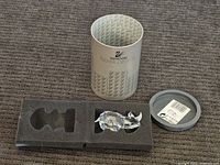 Clear Swarovski Silver Crystal rhinoceros figurine resting in foam insert with original packaging opened and displayed behind it.