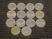 Top and front view of 15 vintage casino tokens, showing variety of $1 tokens from several casinos including Alpine, The Mint, United Nugget, and designs featuring the Stratosphere Tower.