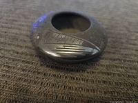 Top view of small round Santa Clara black pottery jar showing carved geometric and linear designs.