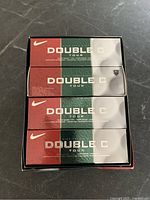 Boxes of Nike Double C Tour golf balls stacked in the lot.