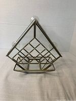 Front angled view showing the triangular brass framed glass feeder with attached suction cups and inner seed shelf.