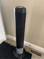 Full view of Seville Classics black standing tower fan with control buttons on top.