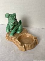 Vintage Sylvac pottery dog ashtray, green glazed dog figure seated on brown ashtray base with repair visible on tail.