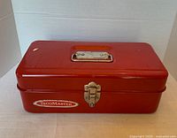 Front view of the red Tecomaster metal tool box showing the latch and brand logo.