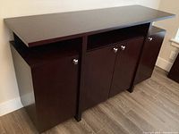 Full front view of the dark wood buffet showing three cabinet doors and solid top surface.