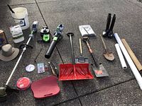 Overview of entire lot on concrete surface showing power tools, shovels, boots, tubes and accessories