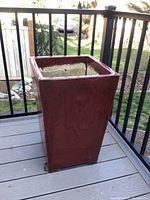 Side view of glossy deep red square ceramic planter showing height and shape.