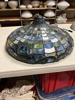 Side view of stained glass shade showing fish scale pattern in blues, greens, purples