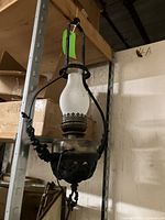 Full front view of black and brass oil hanging light with glass chimney, showing suspended hanging form.